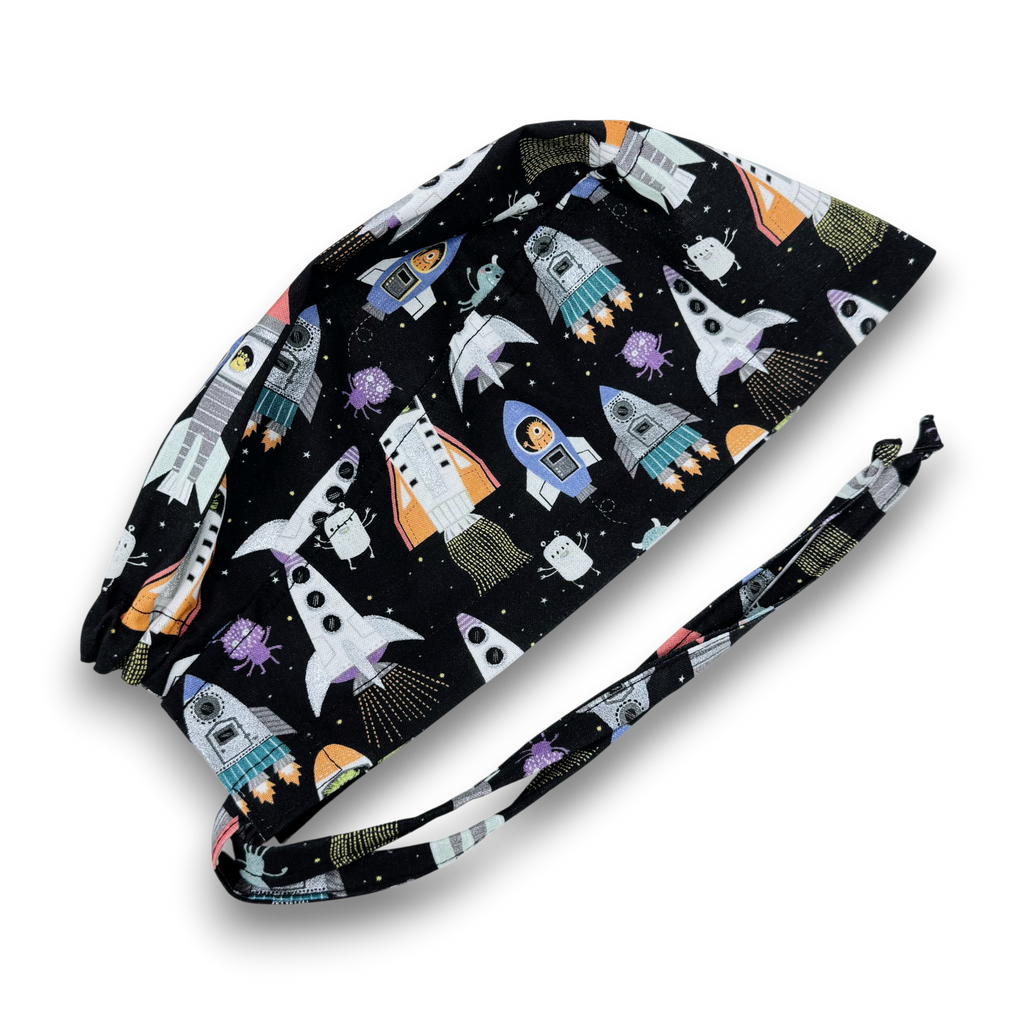 Men's surgical scrub cap. Black Space Rocket Print skull tie-back style scrub hat by Paradise Caps.